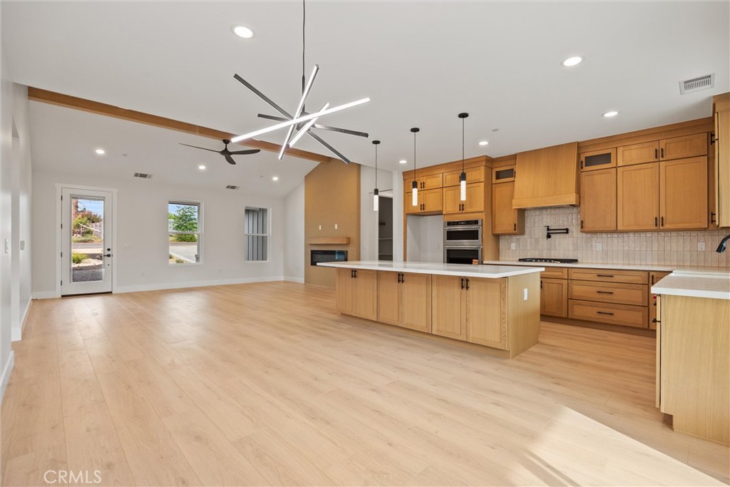 6006 Kibler Road Paradise, CA 95969 - Photo 21 of 43 a large kitchen with stainless steel appliances kitchen island granite countertop a stove a sink a refrigerator and white cabinets with wooden floor