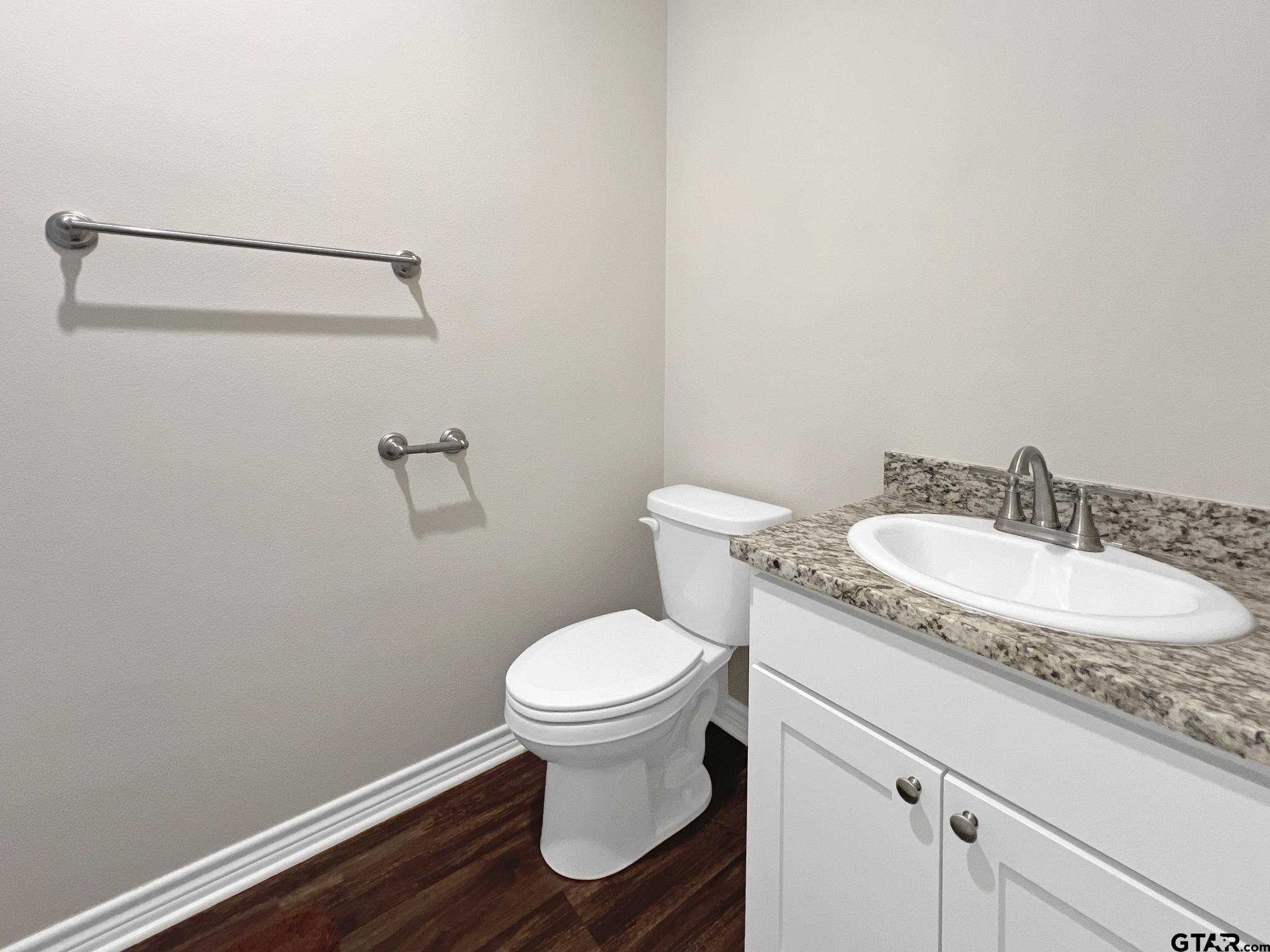 107 Short Street Gilmer, TX 75645 - Photo 17 of 26 a bathroom with a granite countertop toilet and a sink
