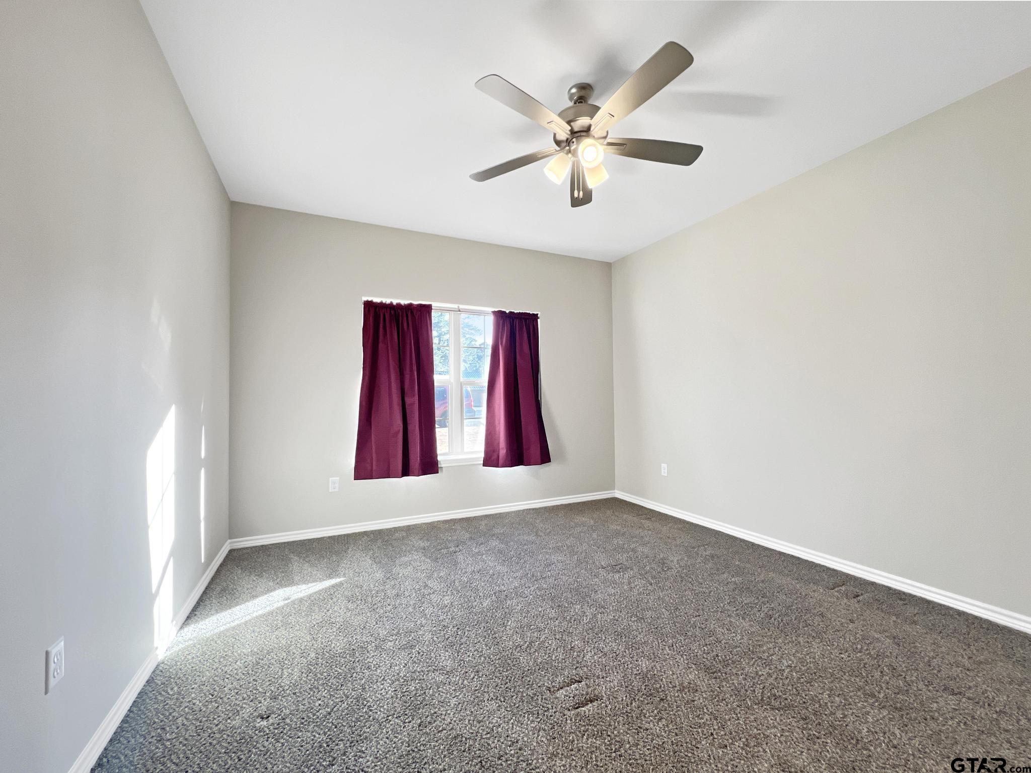 107 Short Street Gilmer, TX 75645 - Photo 9 of 26 an empty room with windows and fan
