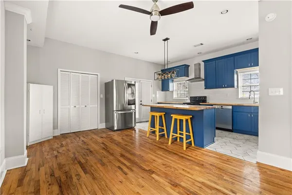 a kitchen with stainless steel appliances kitchen island granite countertop a refrigerator and a stove top oven