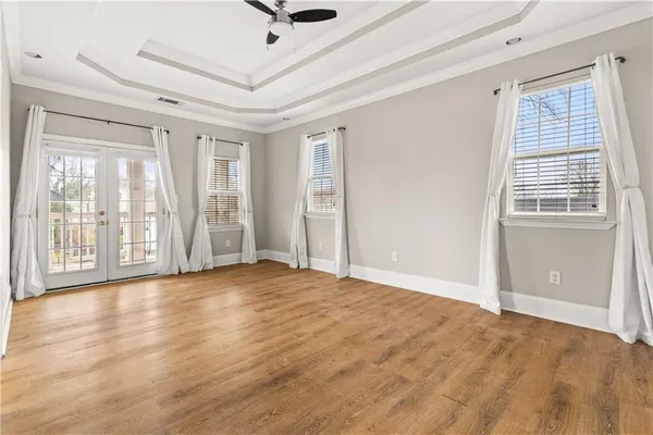 a view of an empty room with window and wooden floor