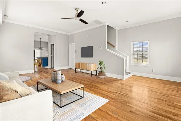 a living room with furniture and a wooden floor