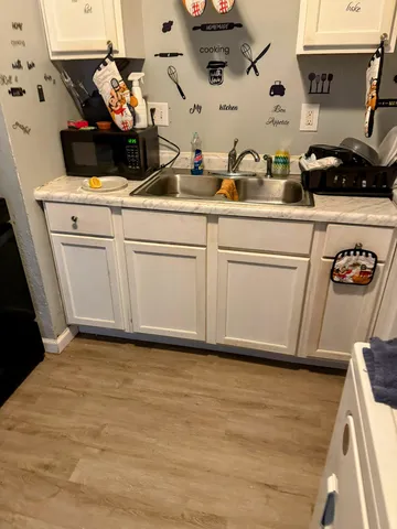 a kitchen with stainless steel appliances a white stove top oven a sink a chimney and cabinets