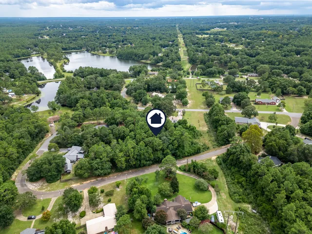 an aerial view of residential house with outdoor space and trees all around