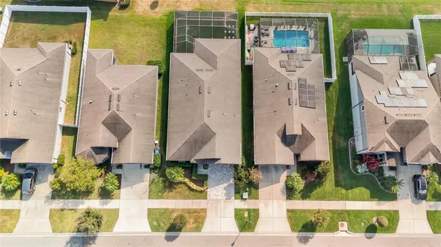 an aerial view of residential houses with outdoor space and parking