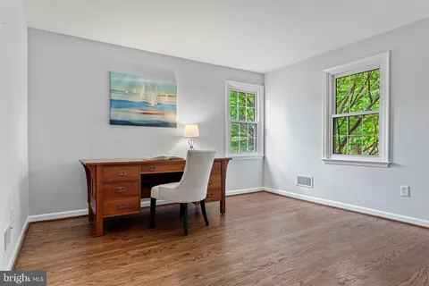 an empty room with a window and wooden floor
