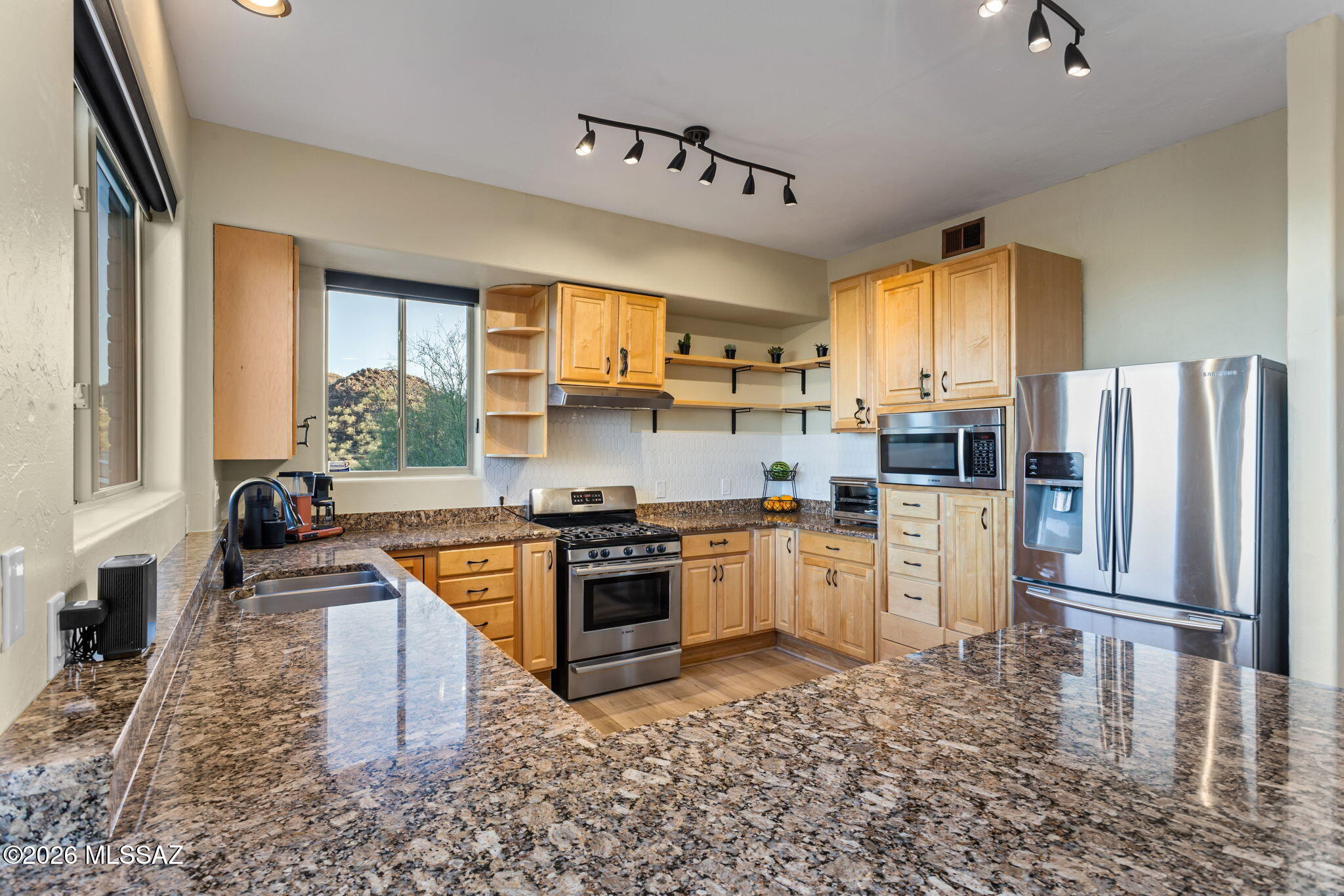 4210 West Mossman Road Tucson, AZ 85746 - Photo 6 of 51 a kitchen with stainless steel appliances granite countertop a stove a sink dishwasher a refrigerator white cabinets and wooden floor