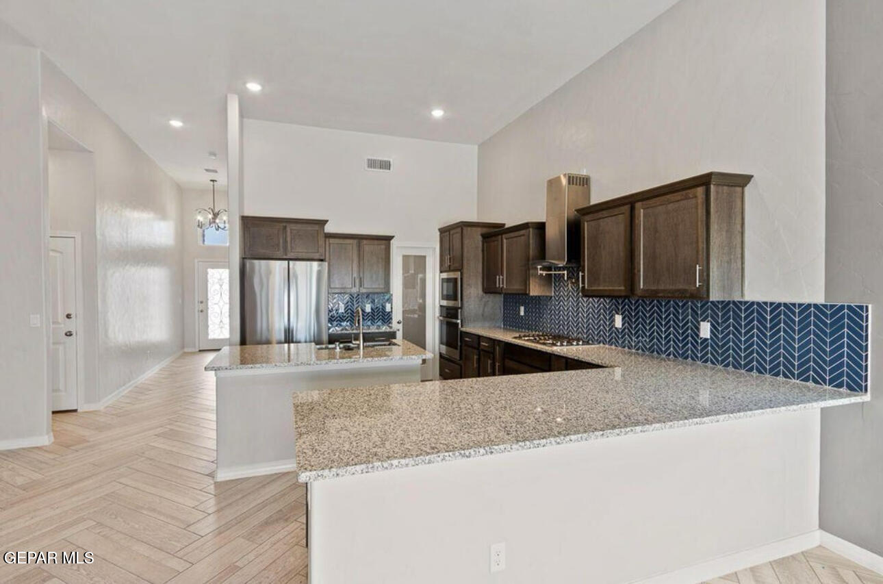 6044 Summer Ridge Street Sunland Park, NM 88008 - Photo 6 of 12 a large kitchen with kitchen island granite countertop a sink and stainless steel appliances