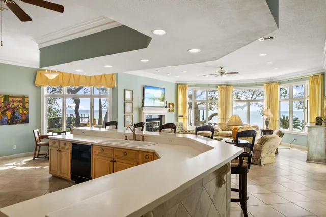 a large dining hall with stainless steel appliances granite countertop a sink and view of living room