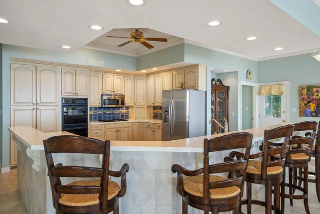 a kitchen with stainless steel appliances kitchen island granite countertop a refrigerator and microwave