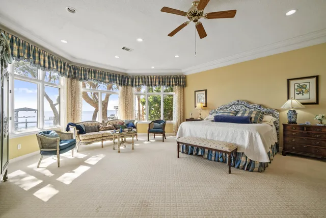 a spacious bedroom with a large bed and a chandelier