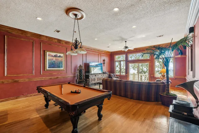 a living room with furniture pool table and a chandelier