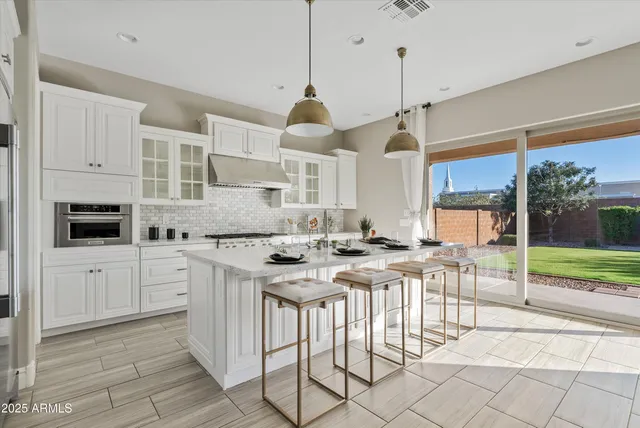 a kitchen with stainless steel appliances granite countertop a stove a sink and a refrigerator