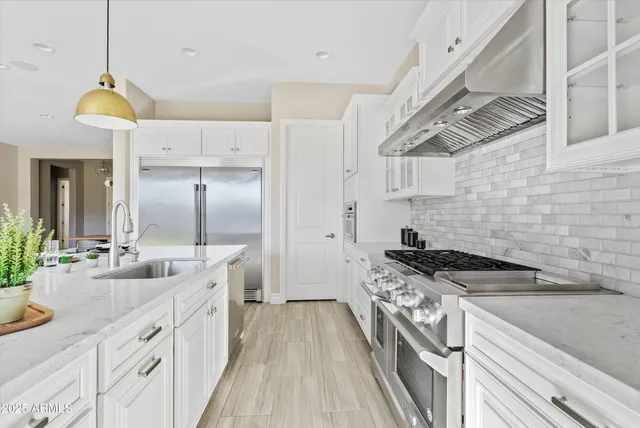 a kitchen with stainless steel appliances granite countertop a sink stove and cabinets