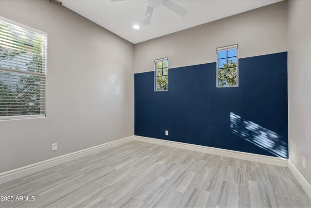 a view of an empty room with wooden floor and closet