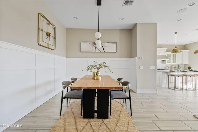 a living room with stainless steel appliances kitchen island granite countertop a table chairs and a view of living room