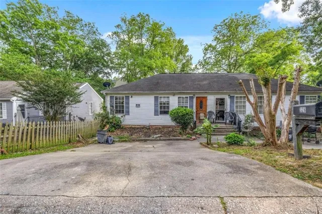 a front view of a house with a yard and garden