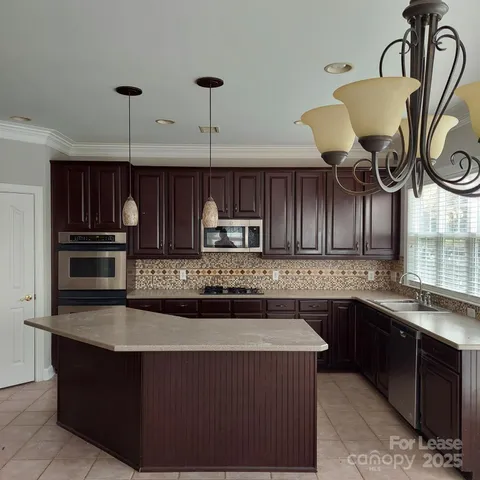 a open kitchen with stainless steel appliances granite countertop a stove a sink a window and a dining table