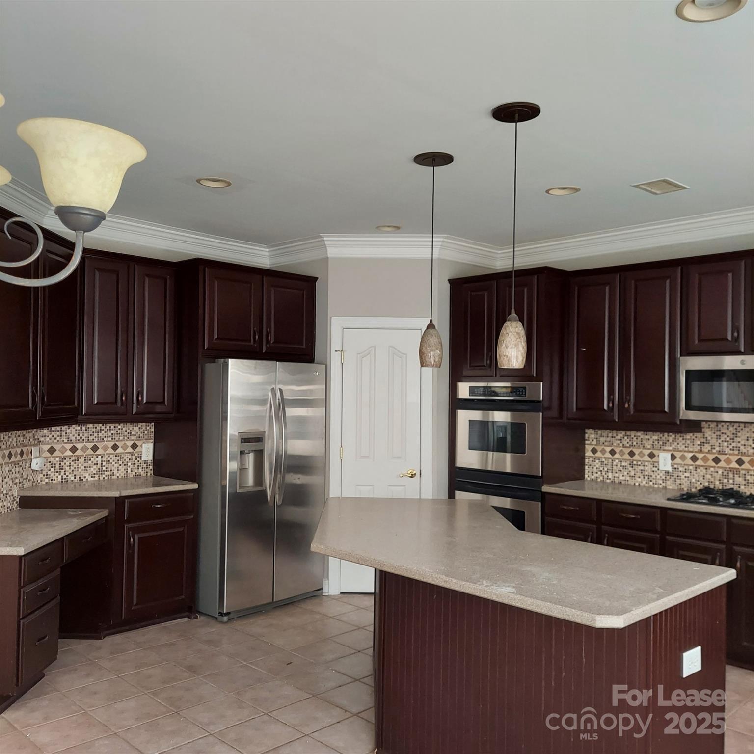 10820 Knight Castle Drive Charlotte, NC 28277 - Photo 13 of 35 a kitchen with stainless steel appliances kitchen island granite countertop a refrigerator a stove and a sink with wooden cabinets