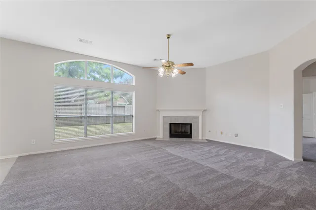 en empty room with windows and fireplace