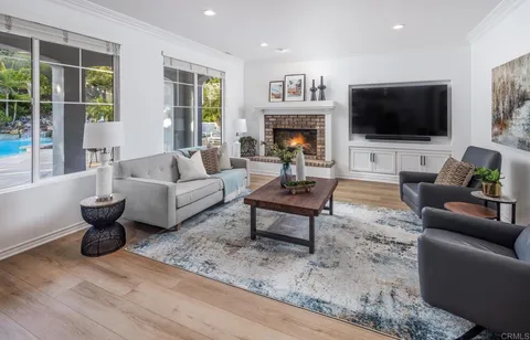 a living room with furniture a flat screen tv and a fireplace