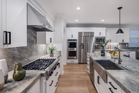 a kitchen with stainless steel appliances granite countertop a sink stove and refrigerator