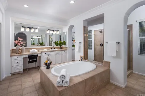 a spacious bathroom with a granite countertop sink mirror and bathtub