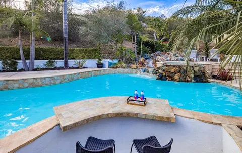 a view of a swimming pool with a patio and garden