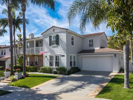 a front view of a house with a garden and palm trees