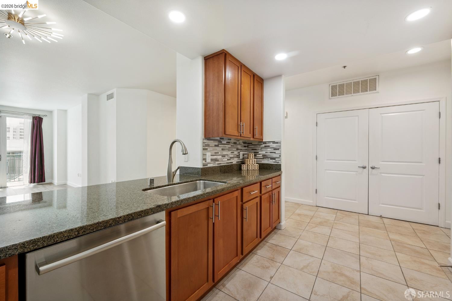 423 7th Street, Unit 303 Oakland, CA 94607 - Photo 16 of 20 Kitchen featuring a peninsula with a stainless steel undermount sink, a gooseneck faucet, and a built-in dishwasher