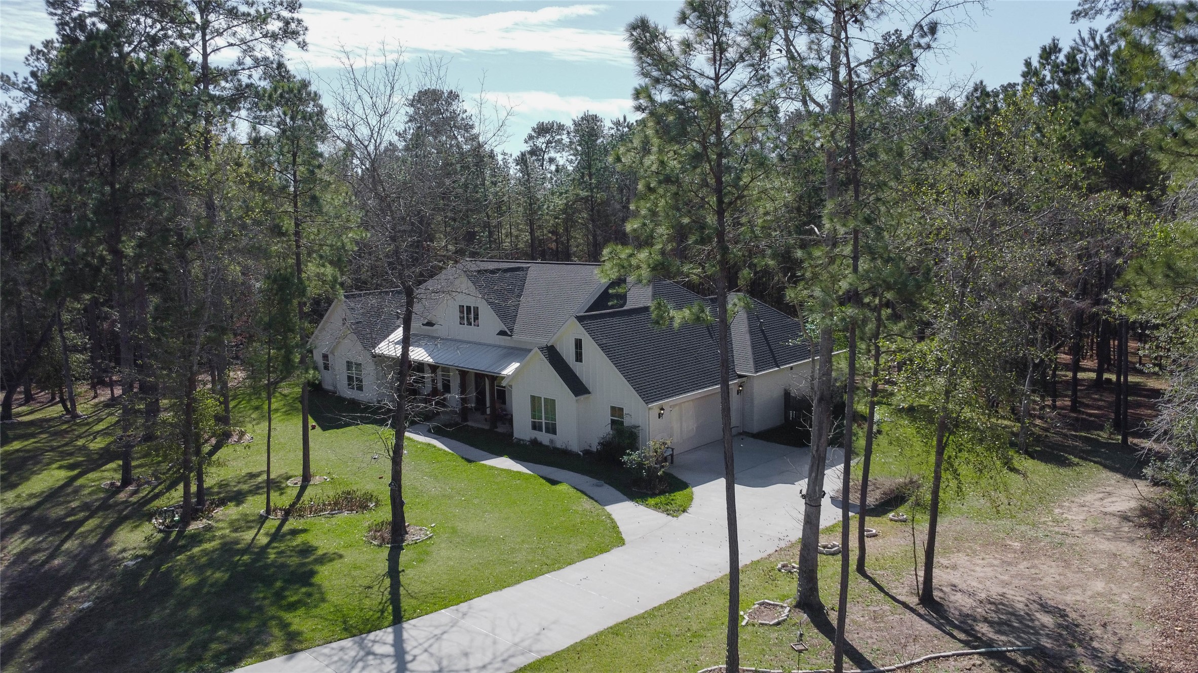 0 Bighorn Road Huntsville, TX 77340 - Photo 19 of 22 Nestled beneath the pines, this gorgeous home exemplifies the rustic elegance of Texas Grand Ranch. With a long concrete driveway, welcoming front porch, and forested backdrop, it highlights the kind of refined rural living the area supports.