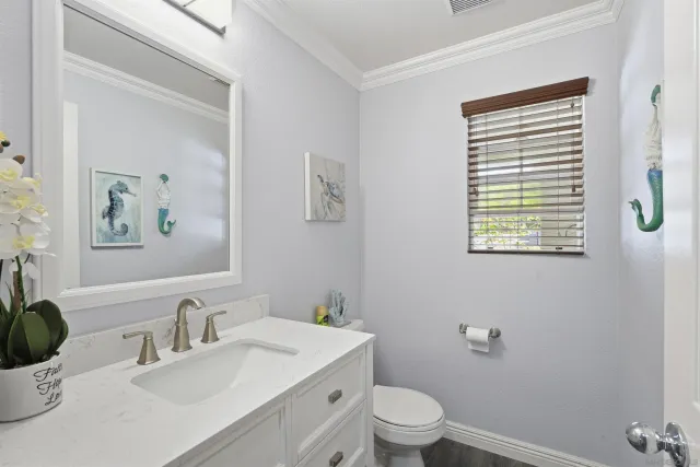 a bathroom with a granite countertop toilet a sink and a mirror