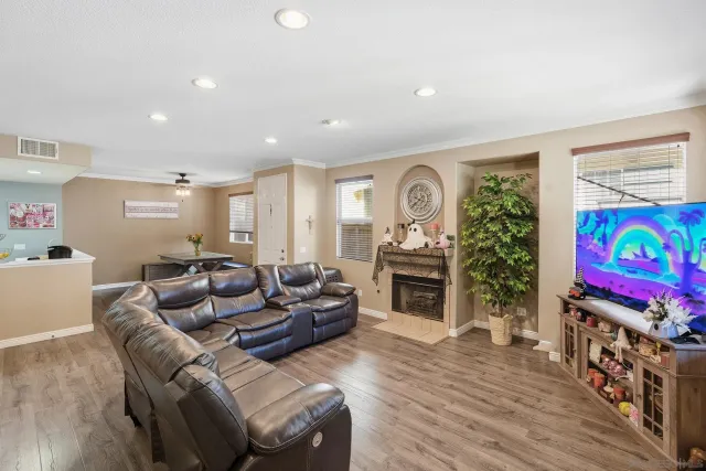 a living room with furniture a flat screen tv and a fireplace