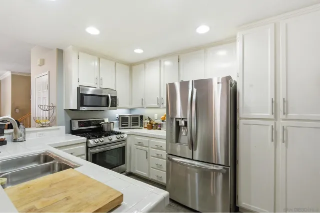 a kitchen with stainless steel appliances granite countertop a refrigerator stove and sink