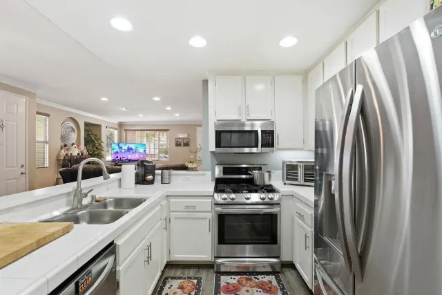 a kitchen with stainless steel appliances a refrigerator sink and microwave
