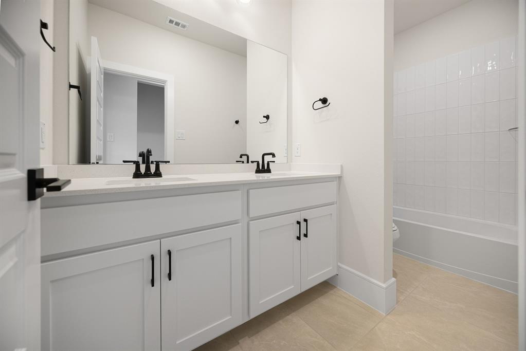 207 Links Court Heath, TX 75126 - Photo 28 of 39 a bathroom with a double vanity sink a mirror and a bathtub