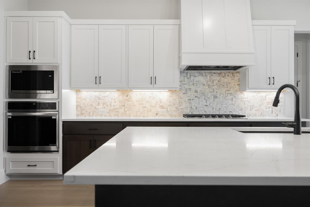 207 Links Court Heath, TX 75126 - Photo 29 of 39 a kitchen with granite countertop white cabinets and stainless steel appliances