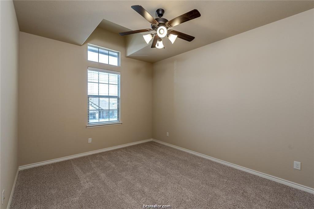 4303 Commando Trail College Station, TX 77845 - Photo 11 of 12 an empty room with windows and chandelier fan