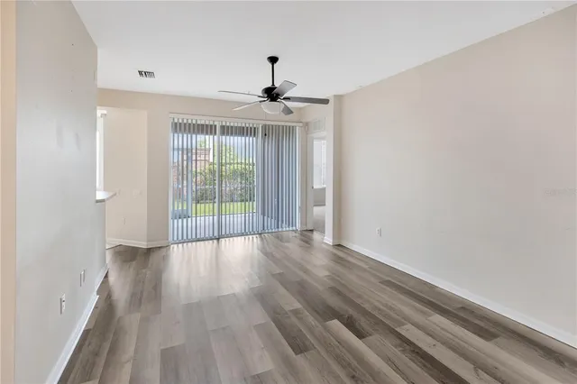 wooden floor in an empty room with a kitchen