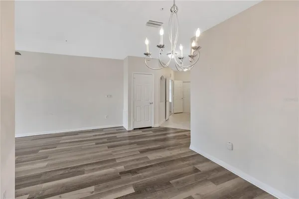 a view of empty room with wooden floor and ceiling fan