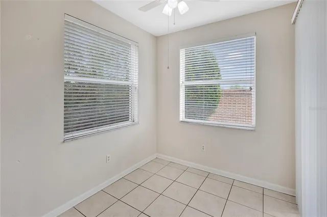 an empty room with a window and a fan