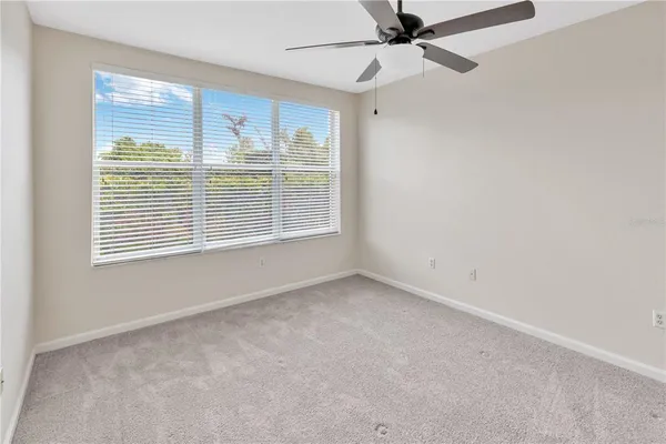 an empty room with closet and a ceiling fan