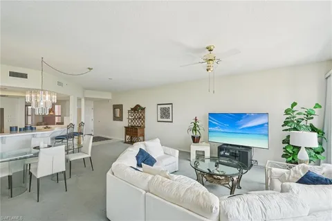 a living room with furniture a chandelier and a window