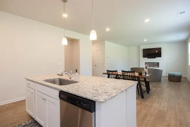 a kitchen with granite countertop kitchen island a sink appliances and a counter top space
