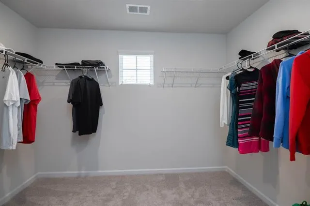 a view of walk in closet with clothes and shoes