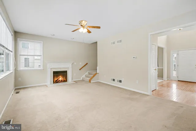 an empty room with windows and fireplace