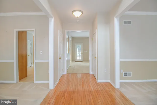a view of a room with wooden floor and a bathroom