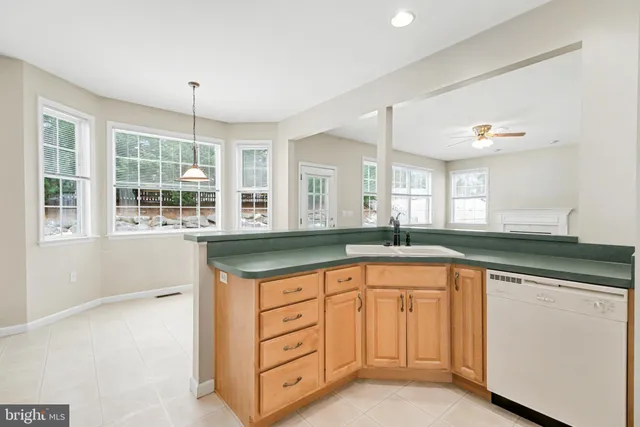 a kitchen with white cabinets and sink