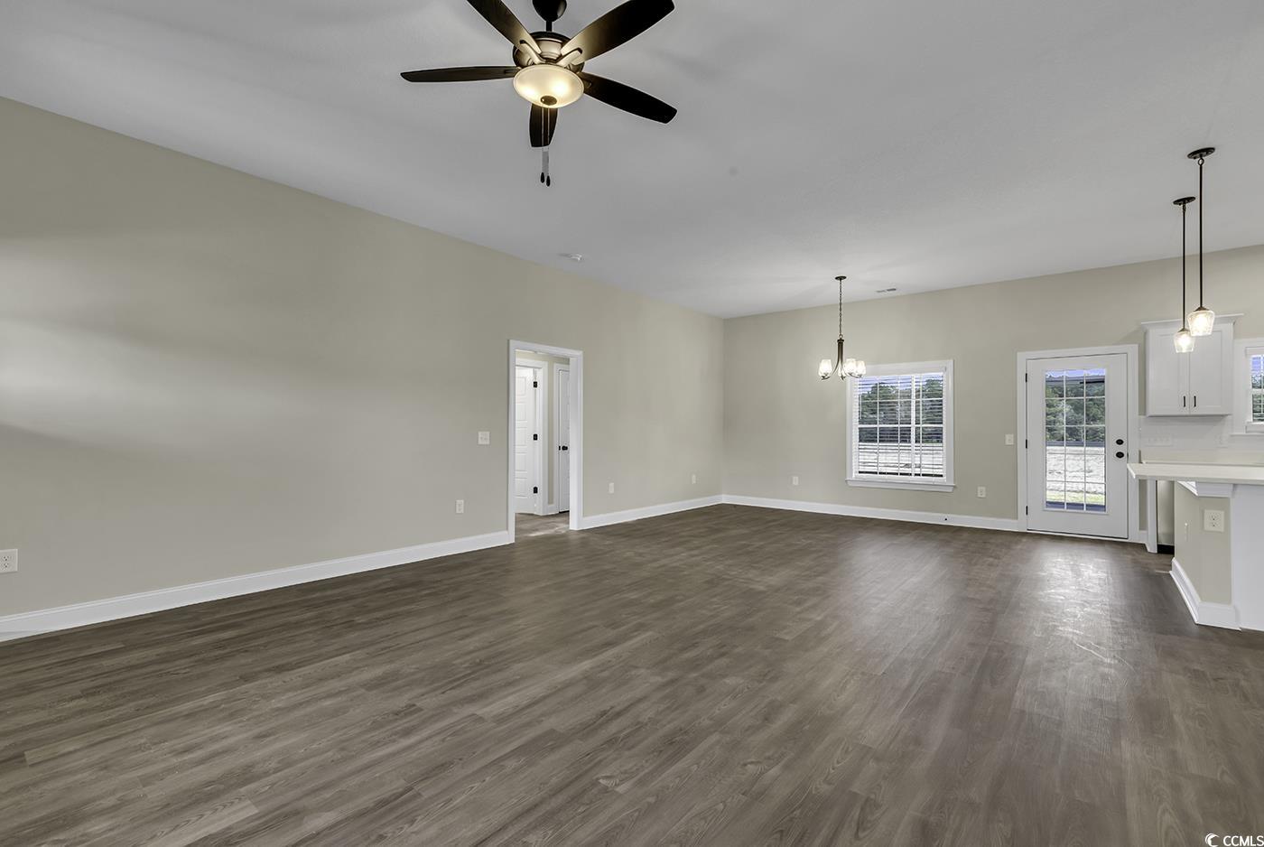 3255 Red Bluff Road Loris, SC 29569 - Photo 13 of 38 Unfurnished living room featuring dark wood-style floors, ceiling fan, and a chandelier