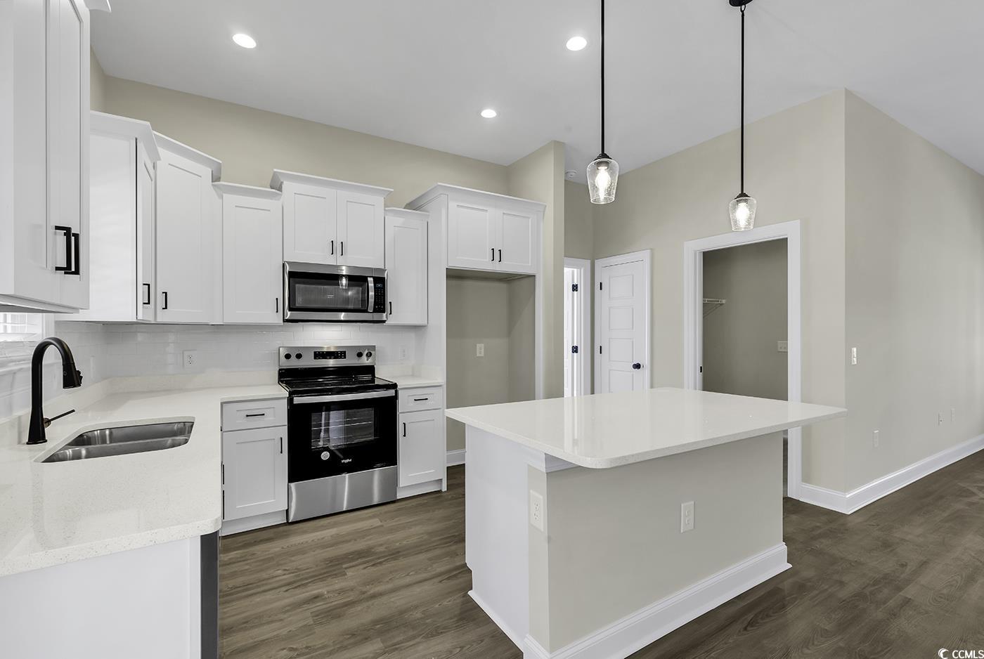 3255 Red Bluff Road Loris, SC 29569 - Photo 17 of 38 Kitchen featuring stainless steel appliances, backsplash, a center island, pendant lighting, and light stone countertops